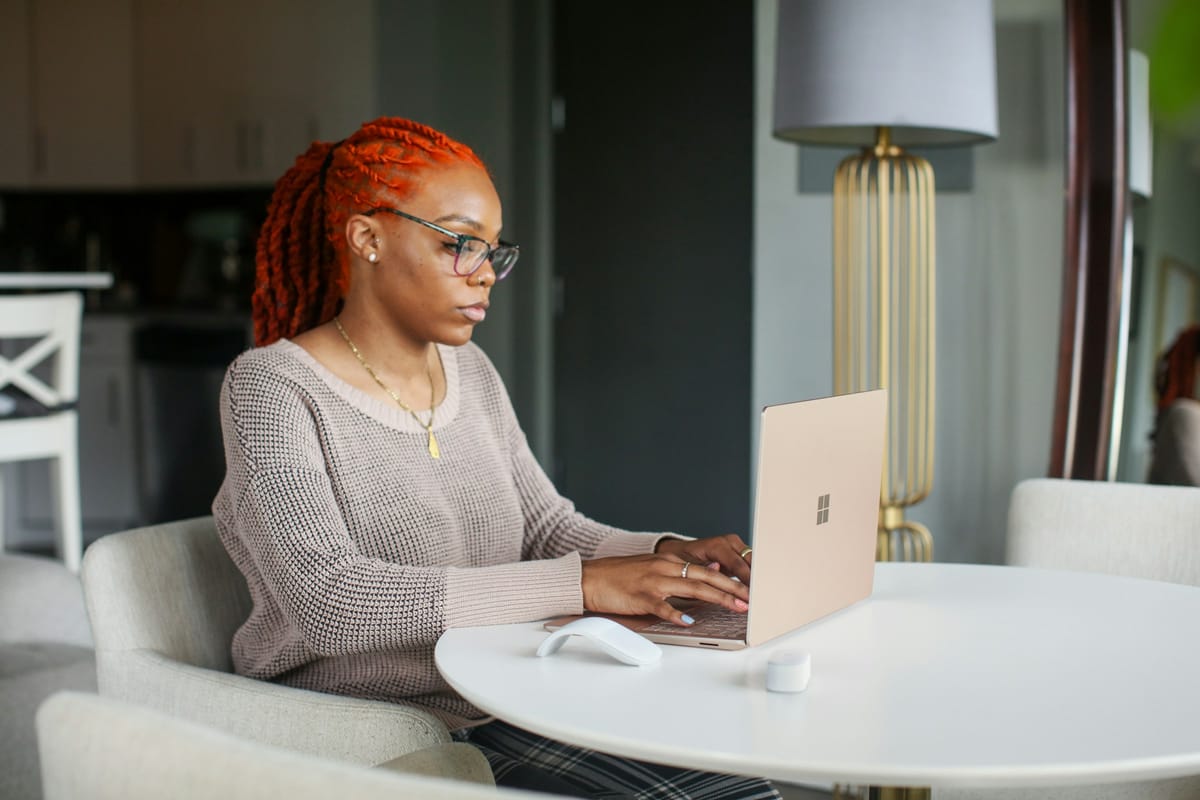 woman using a laptop - Microsoft Loop vs Notion